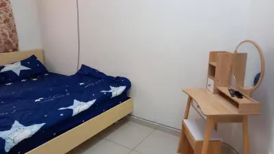a bedroom with a bed with a blue comforter and a table at Homestay Zaki D'Gerik in Gerik
