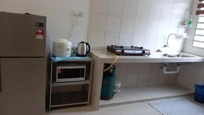 a small kitchen with a microwave and a sink at Homestay Zaki D'Gerik in Gerik