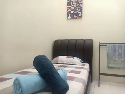a person laying on a bed with a stuffed animal on it at KH Homestay Comfy N Calm in Seri Manjung
