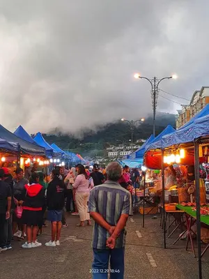 a crowd of people standing around a market with blue tents at GUNONG HOMESTAY at Golden Hills CameronHighlands in Cameron Highlands