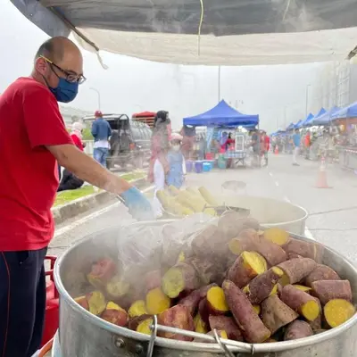 a man cooking food in a pot on a grill at GUNONG HOMESTAY at Golden Hills CameronHighlands in Cameron Highlands