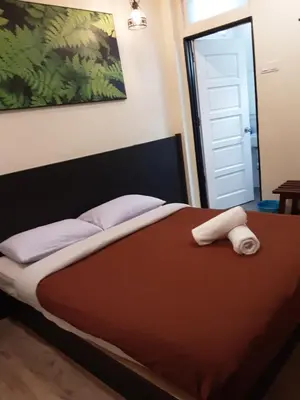 a bedroom with a bed with a brown comforter at Hillview Inn Cameron Highlands PROMO in Tanah Rata