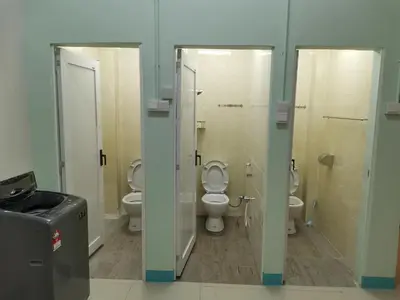 a bathroom with two toilets and a sink and two mirrors at Color Mixed Home Hostel in George Town