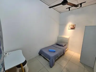 a small room with a small bed and a table at Color Mixed Home Hostel in George Town