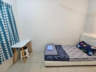 a small bedroom with a bed and a table at Color Mixed Home Hostel in George Town