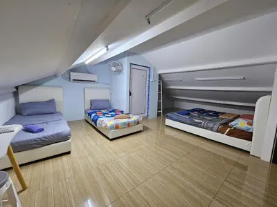a room with two beds and a door in it at Color Mixed Home Hostel in George Town
