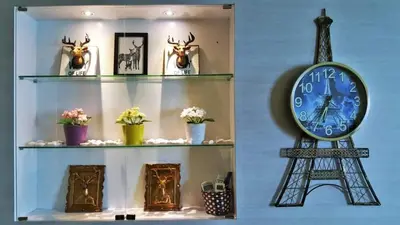 a shelf with a clock and the eiffel tower at Mansion One Peaceful Homestay in George Town