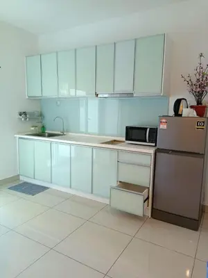 a kitchen with white cabinets and a refrigerator at Mansion One Peaceful Homestay in George Town