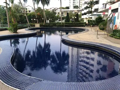 a swimming pool in a city with trees in the water at Beach Resort 7 Home Stay SRI SAYANG APARTMENT BATU FERRINGHI 3BEDROOM in Batu Ferringhi