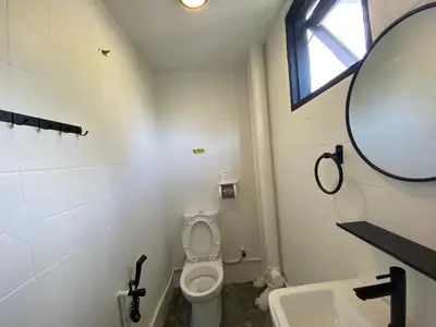 a bathroom with a toilet and a sink and a mirror at Aurora Court Service Apartment in George Town