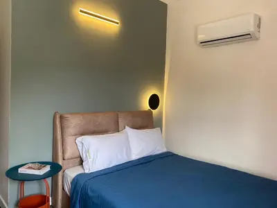a bedroom with a bed with a blue bedspread and a table at Aurora Court Service Apartment in George Town