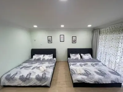 two beds sitting next to each other in a bedroom at EquatorialHillResort SunsetView 10Min Popular FARM in Brinchang