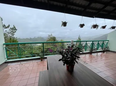 a balcony with a table and flowers on it at EquatorialHillResort SunsetView 10Min Popular FARM in Brinchang
