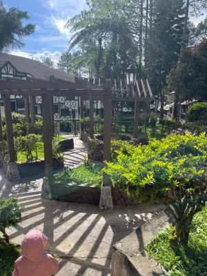 a little girl sitting in front of a garden at EquatorialHillResort SunsetView 10Min Popular FARM in Brinchang