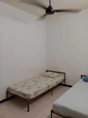 a bed sitting in a room with a ceiling fan at Homestay Idaman Penang in Permatang Pauh