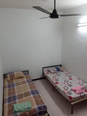 a bedroom with two beds and a ceiling fan at Homestay Idaman Penang in Permatang Pauh