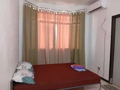 a room with a bed in front of a window at Homestay Idaman Penang in Permatang Pauh