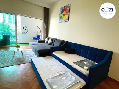 a living room with a blue couch and a table at Instagramable Luxury Suites for Couples or Families • Straits Quay Penang • Sea View Balcony • Private Bathtub in Bagan Jermal