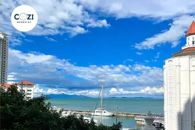 a white building with a sail boat in the water at Instagramable Luxury Suites for Couples or Families • Straits Quay Penang • Sea View Balcony • Private Bathtub in Bagan Jermal