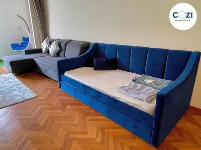 a blue couch sitting in a living room at Instagramable Luxury Suites for Couples or Families • Straits Quay Penang • Sea View Balcony • Private Bathtub in Bagan Jermal