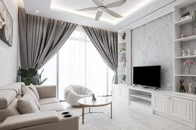 a white living room with a white couch and a television at Beacon Executive Suites by Simply Penang in George Town