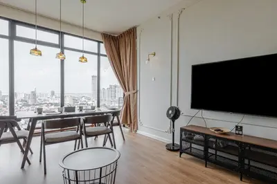 a dining room with a table and a large screen tv at Beacon Executive Suites by Simply Penang in George Town