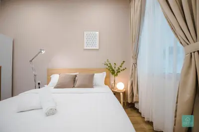 a bedroom with a white bed and a window at Jomstay MUJI 19 & 7 INN Ipoh Garden 8-10 pax in Ipoh