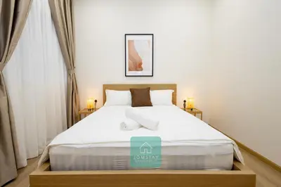 a bedroom with a large bed with white sheets at Jomstay MUJI 19 & 7 INN Ipoh Garden 8-10 pax in Ipoh