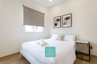 a white bedroom with a bed with a sign on it at Jomstay MUJI 19 & 7 INN Ipoh Garden 8-10 pax in Ipoh