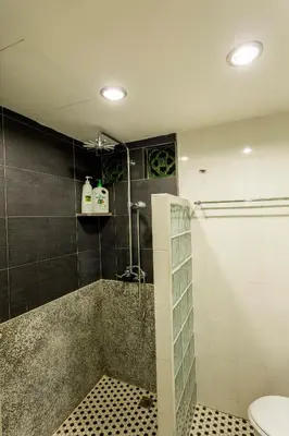 a bathroom with a shower with a sink and a toilet at Sri Sayang Seaview Holiday Home in Batu Ferringhi