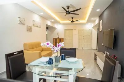a dining room with a glass table and a couch at Sri Sayang Seaview Holiday Home in Batu Ferringhi