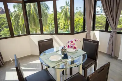 a dining room with a glass table and chairs at Sri Sayang Seaview Holiday Home in Batu Ferringhi