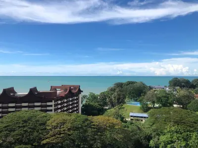a view of the water and a building at Sri Sayang Seaview Holiday Home in Batu Ferringhi