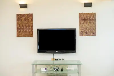 a flat screen tv hanging on a wall at Sri Sayang Seaview Holiday Home in Batu Ferringhi