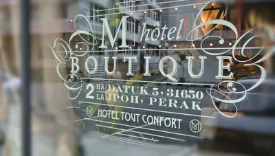 a window with a sign for a hotel boutique at M Boutique Hotel in Ipoh