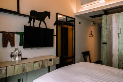 a room with a tv with a horse on the wall at M Boutique Hotel in Ipoh