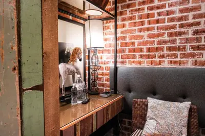 a mirror on a brick wall with a woman in a mirror at M Boutique Hotel in Ipoh