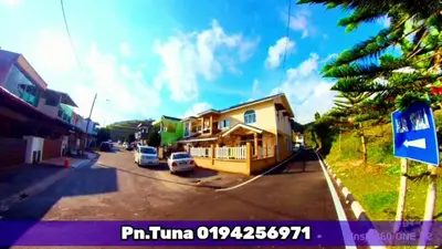 a view of a street with a house and a street sign at Tuna Cameron Homstay in Brinchang