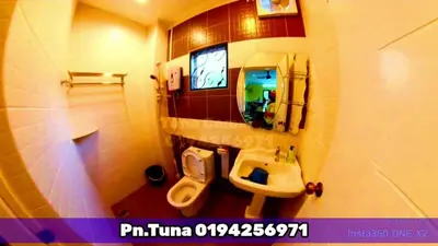 a bathroom with a sink and a toilet and a mirror at Tuna Cameron Homstay in Brinchang