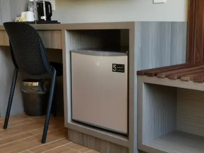 a small refrigerator in a cabinet next to a chair at VENO HOTEL in George Town