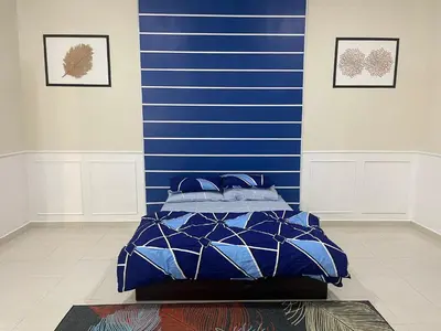 a bed in a room with a blue wall at No 61 Nazirin Homestay Tmn Indah Raya 2 Manjung Lumut in Lumut