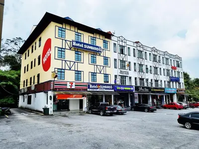 a large building with cars parked in a parking lot at Hotel Sun Birds in Cameron Highlands