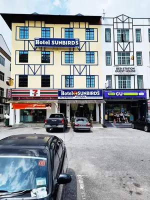 a large building with cars parked in front of it at Hotel Sun Birds in Cameron Highlands