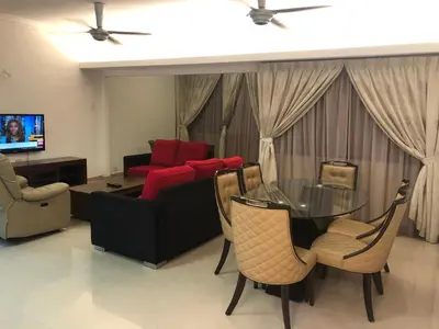 a living room with a glass table and a couch at Beach Resort 19 Home Stay SRI SAYANG APARTMENT BATU FERRINGHI 3BEDROOM in Batu Ferringhi