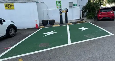 a parking lot with a green and white arrow painted on the street at Beach Resort HOME STAY SRI SAYANG 05 APARTMENT BATU FERRINGHI 2BEDROOM in Batu Ferringhi