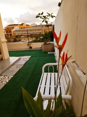a white bench sitting on top of a green lawn at Pinang Beach Cottage @ Ferringhi in Batu Ferringhi