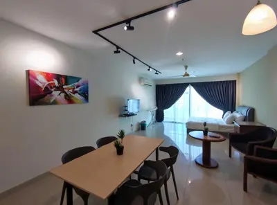 a living room with a table and chairs and a bedroom at Marina Island Lumut HomeHotel in Lumut