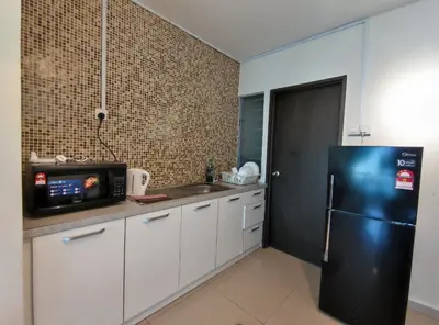 a kitchen with a black refrigerator and a sink at Marina Island Lumut HomeHotel in Lumut