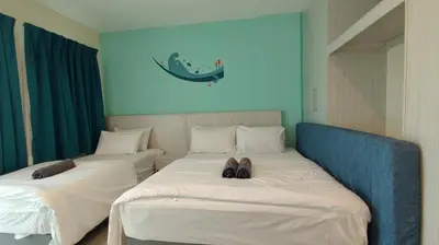 a room with two beds with shoes on them at Marina Island Lumut HomeHotel in Lumut