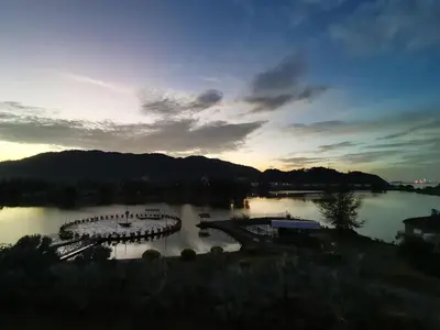 a view of a lake with a marina at sunset at Marina Island Lumut HomeHotel in Lumut